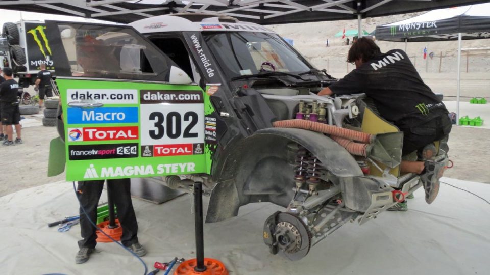 Mechanici týmu X-Raid při práci na voze Mini Stéphana Peterhansela